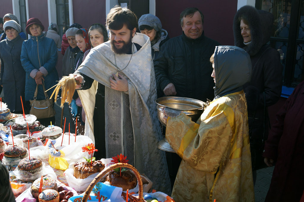 Священник освящает куличи